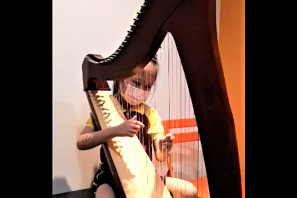 低年級參加者用豎琴彈奏一曲