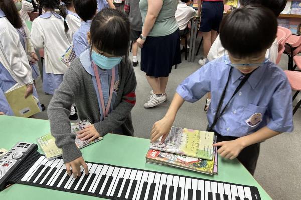 同學在午膳小息圖書館活動中探究特色小樂器的演奏方法